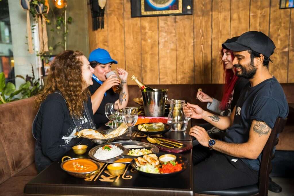 Friends enjoying dinner at a cozy restaurant, captured by Photographer Helsinki, specializing in custom photography and food photography.