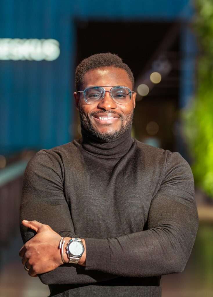 Confident man smiling in turtleneck and glasses