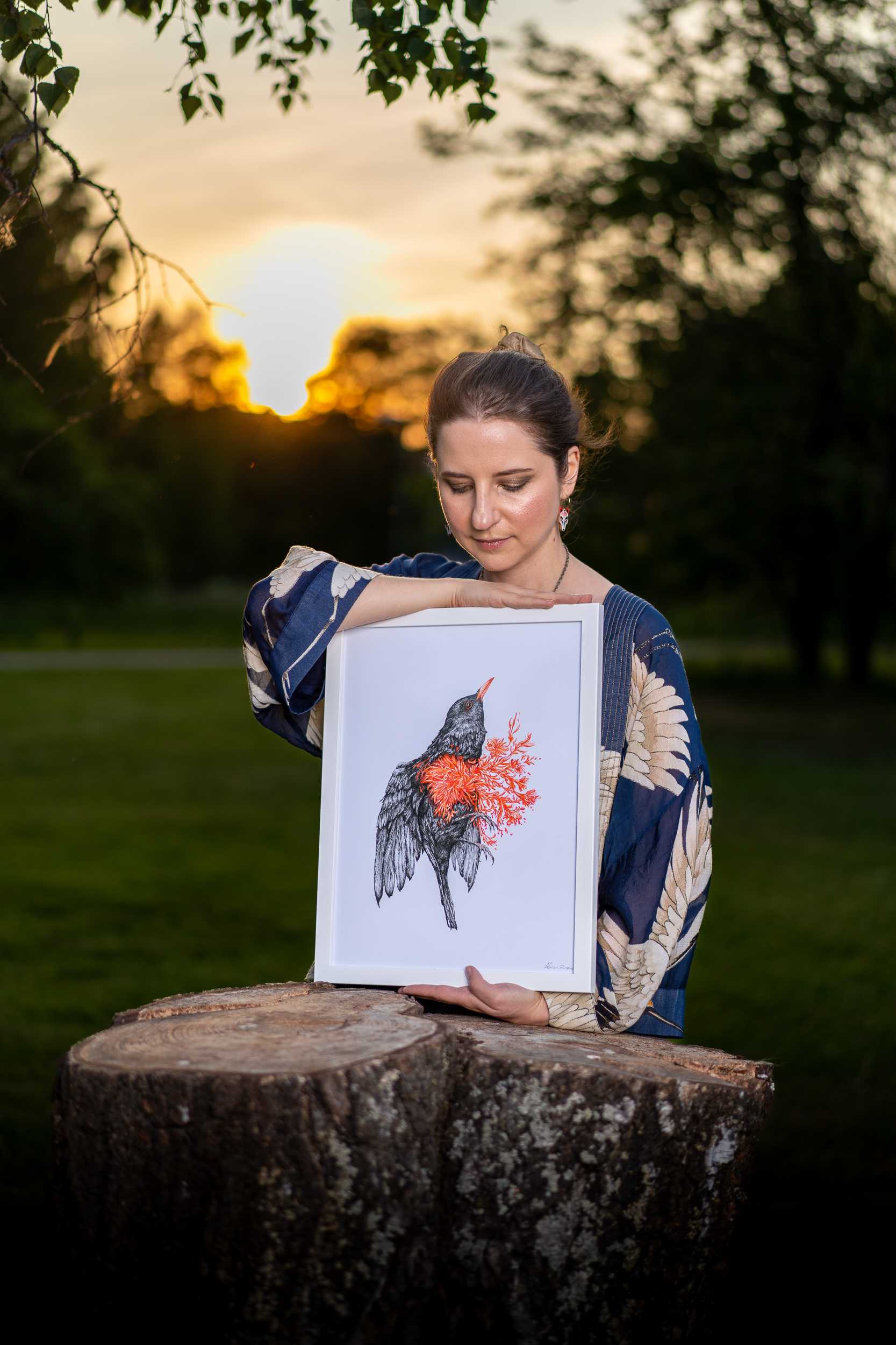 Woman showcasing artwork at sunset, captured by Photographer Helsinki, specializing in custom photography and customized photo solutions.