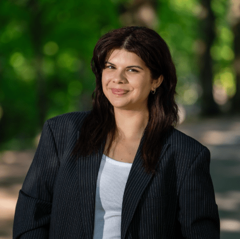 Professional corporate headshot of a smiling woman outdoors in Helsinki.